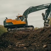 orange and white excavator on brown ground during daytime