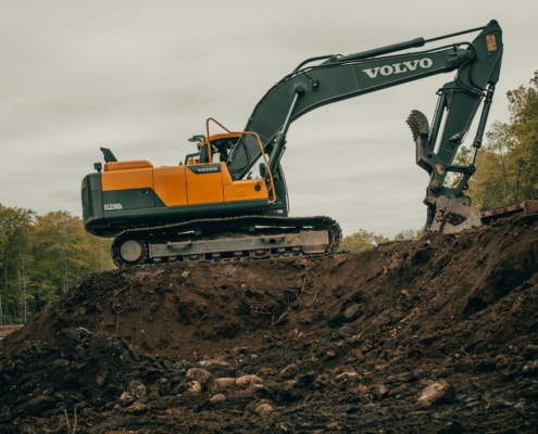orange and white excavator on brown ground during daytime