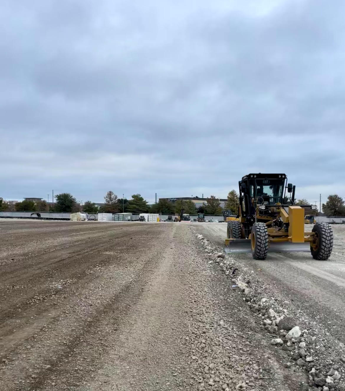 Motor grader grading a large commercial site pad