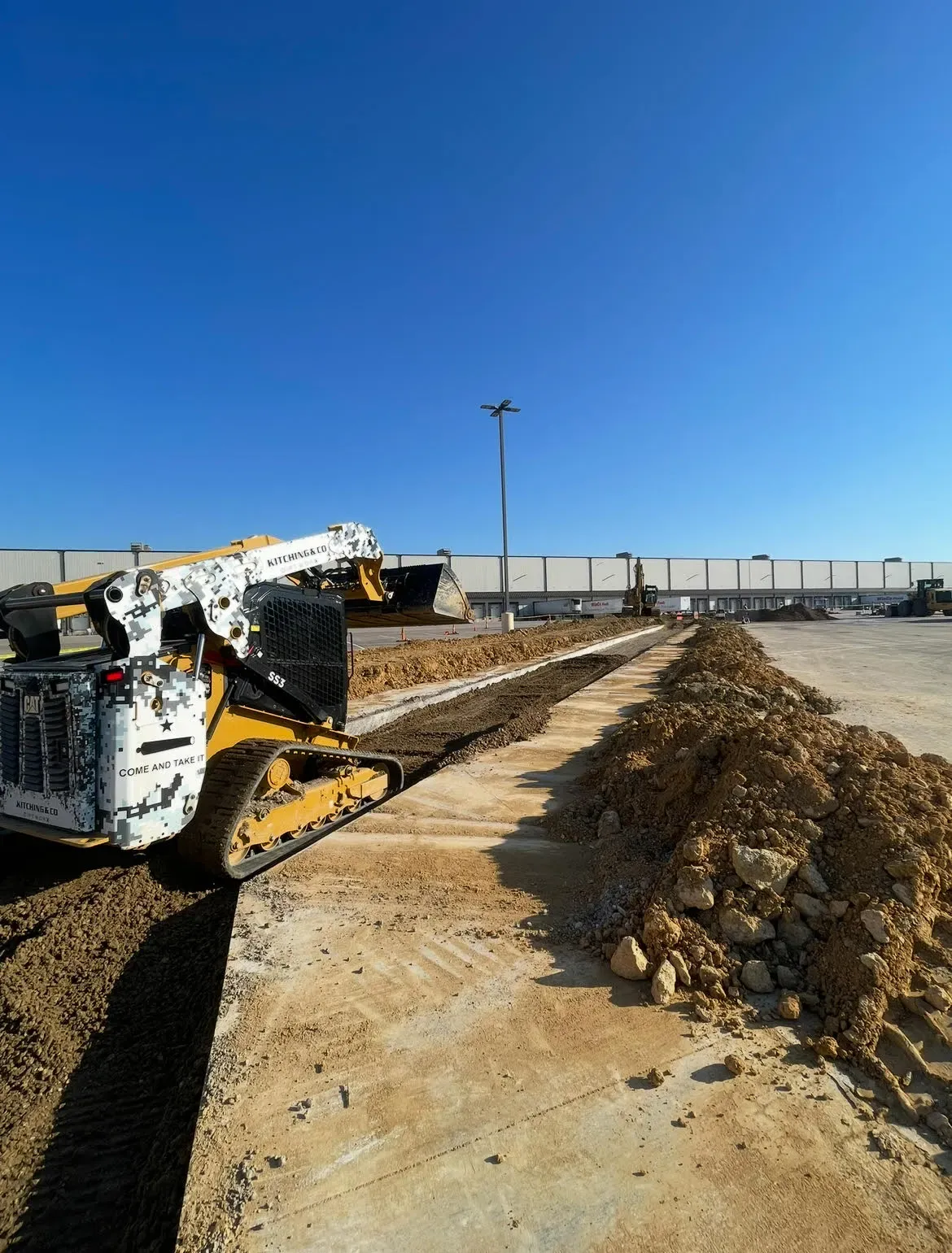 Compact track loader working along an underground utility trench